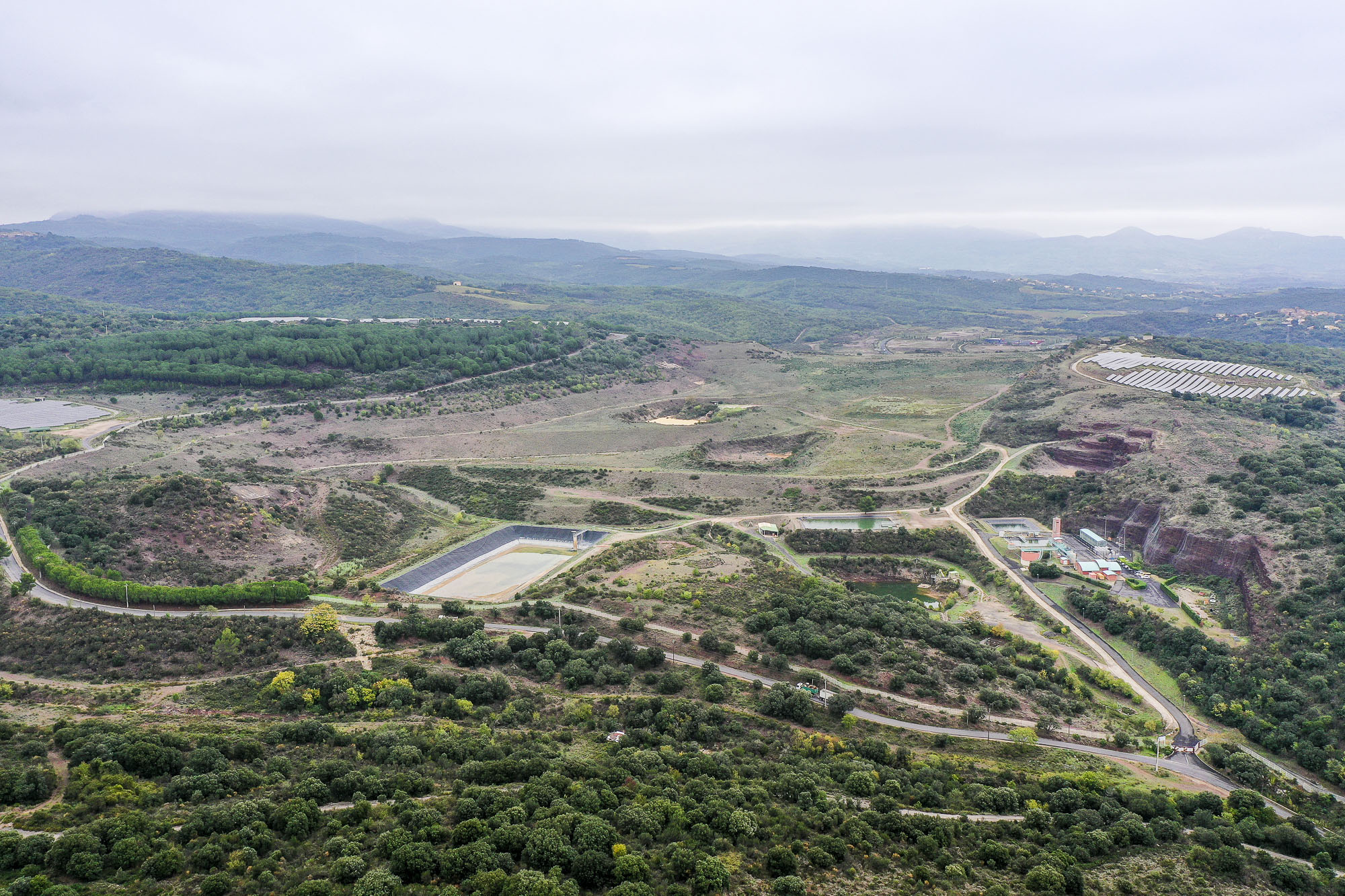 Vue aérienne de l'ancien complexe minier (mas Lavayre), en octobre 2022. On y voit la station pour le traitement des eaux d'exhaure et de ruissèlement, à gauche et à droite deux centrales solaires photovoltaïques et l'OZE Michel chevalier, à l'arrière.