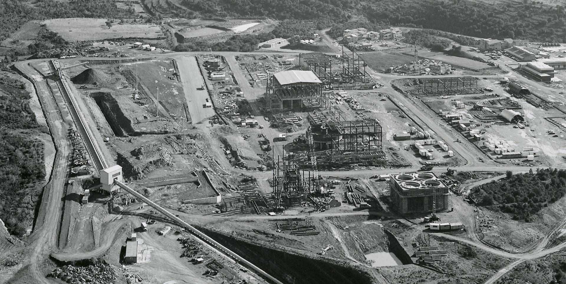 Vue aérienne du carreau minier (mas Lavayre), le 04 mars 1980. L'usine de traitement des minéraux la « SIMO » est en cours de construction, en connexion avec les travaux miniers souterrains au premiers plan.