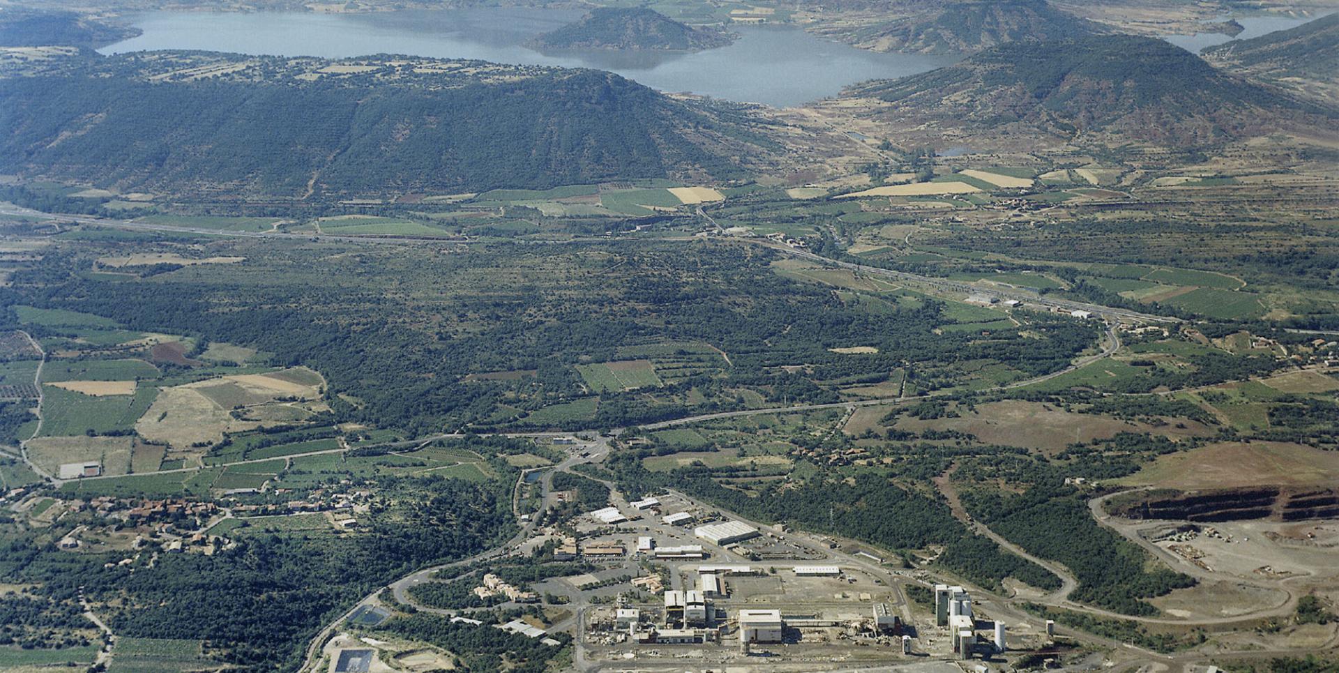 Vue aérienne du complexe minier d'extraction (le mas Lavayre) en cours de démantèlement, le 23 juin 1999. La carreau minier avec l'usine de traitement au premier plan, à l'arrière, le lac du Salagou.