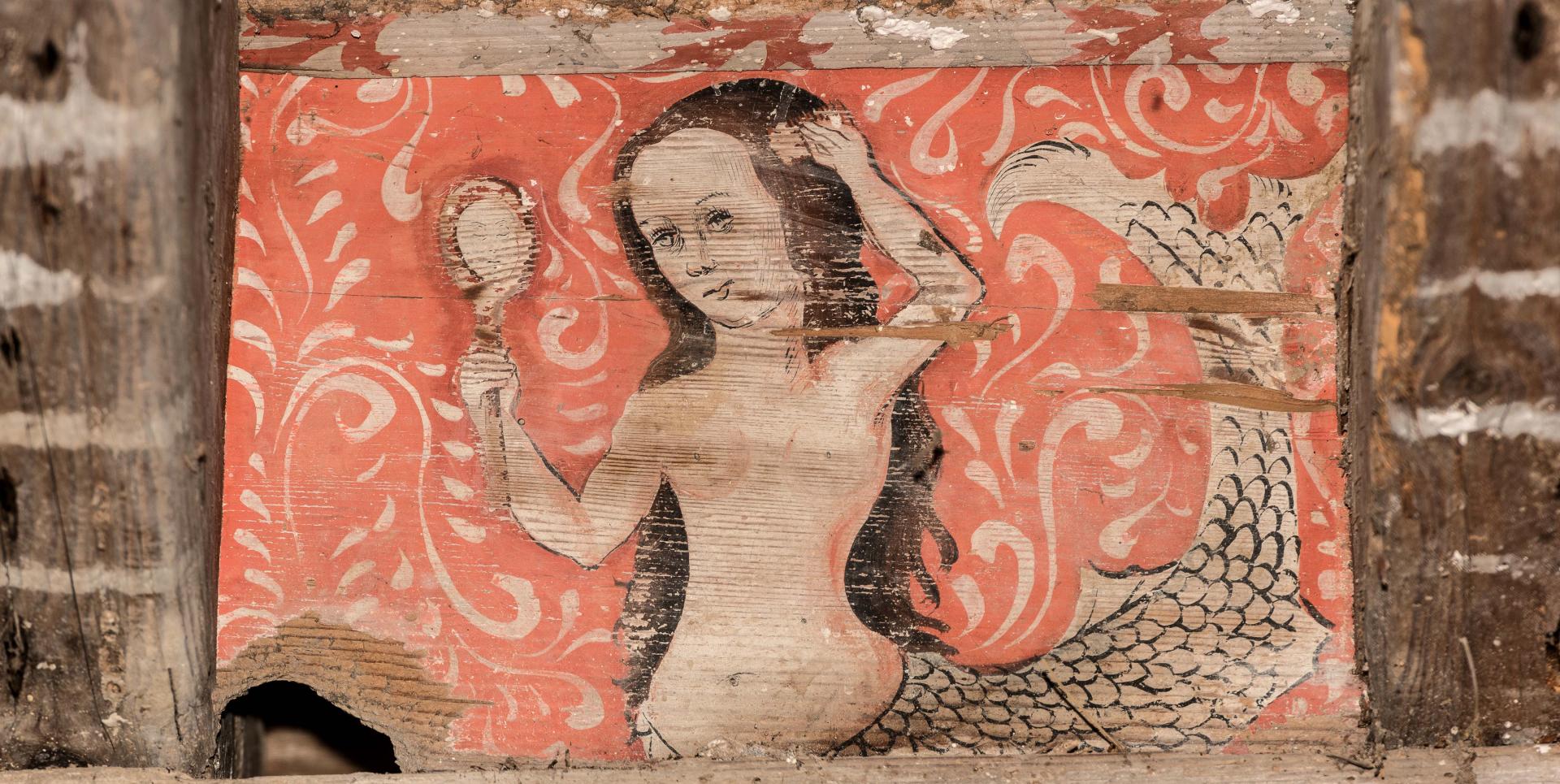Sirène se regardant dans un miroir et se peignant les cheveux.